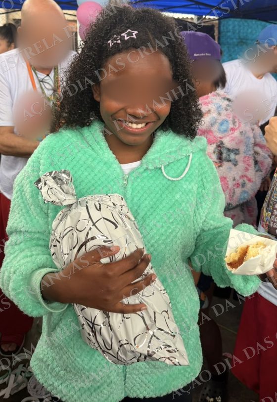 Criança sorri com seu presente no Dia das Crianças