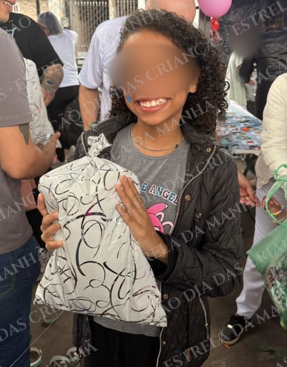 Criança sorri com seu presente no Dia das Crianças