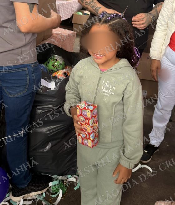 Criança sorri com seu presente no Dia das Crianças